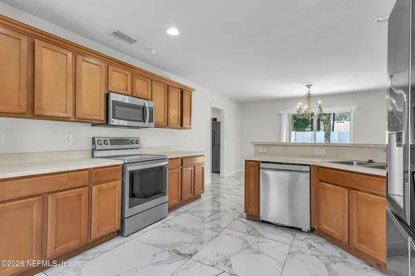 a kitchen with stainless steel appliances granite countertop a stove top oven a sink dishwasher and a microwave oven on the blue kitchen countertops