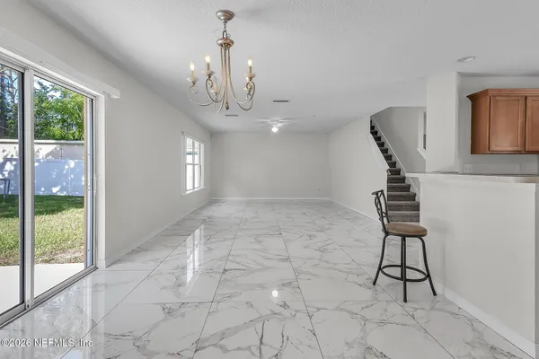 a view of a hallway with windows and chandelier