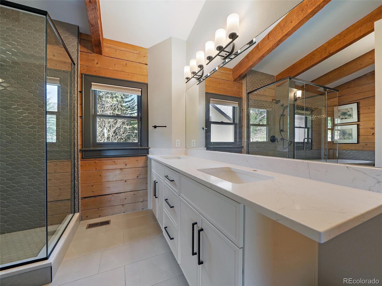24 Pine Valley Road Evergreen, CO 80439 - Photo 17 of 50 a spacious bathroom with a sink a large mirror and a shower