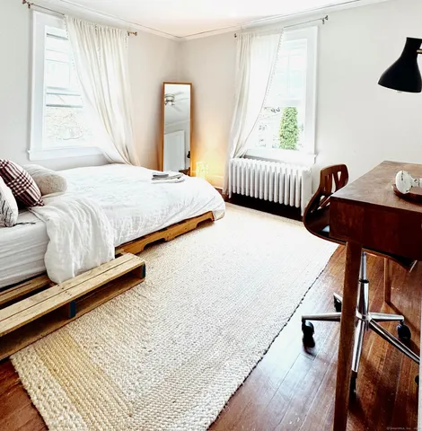 a bedroom with a bed a window and dresser