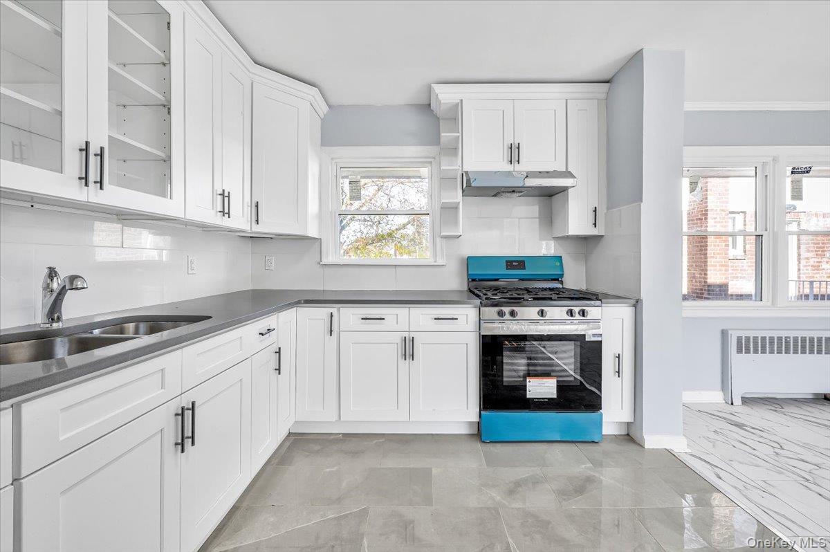 95 Harold Avenue Hempstead, NY 11550 - Photo 11 of 29 a kitchen with stainless steel appliances white cabinets and a stove top oven