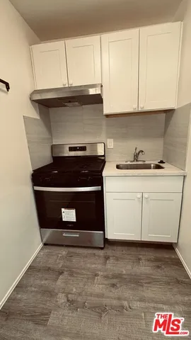 a kitchen with granite countertop a stove and a microwave