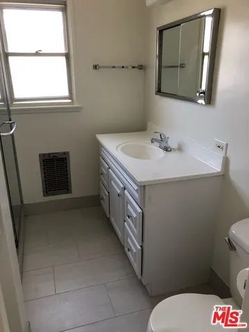 a bathroom with a sink a toilet and mirror