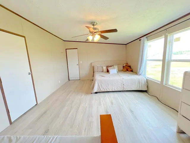 a bedroom with a bed and wooden floor