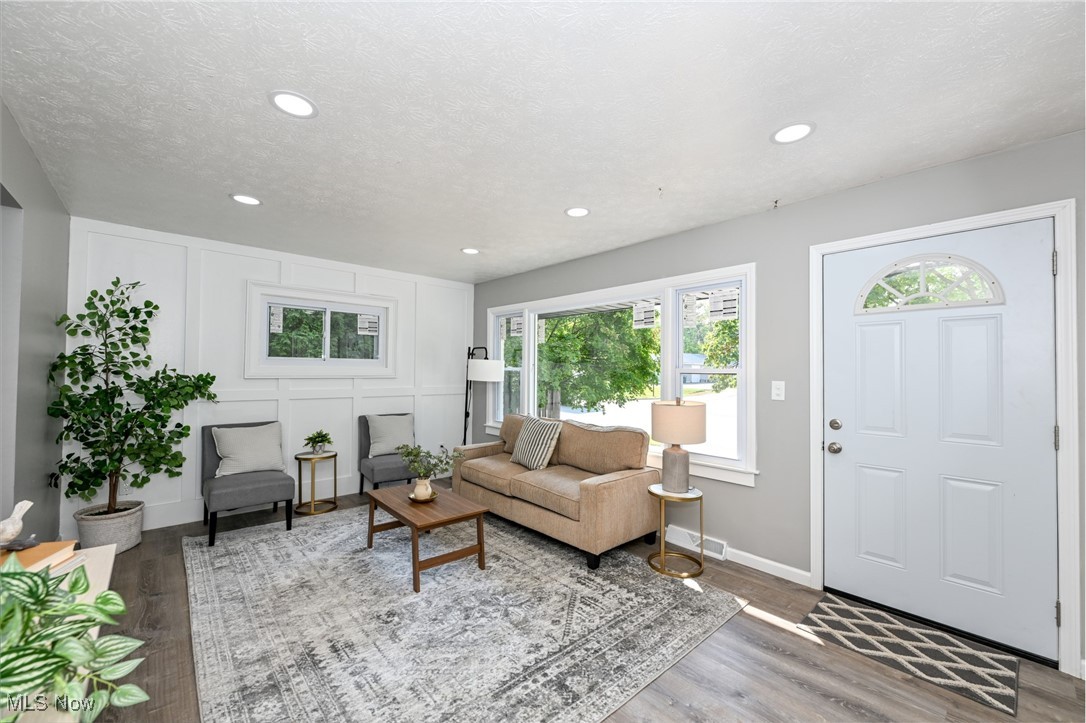 263 Forbes Road Bedford, OH 44146 - Photo 7 of 20 Living room featuring a textured ceiling, light wood-type flooring, and a healthy amount of sunlight