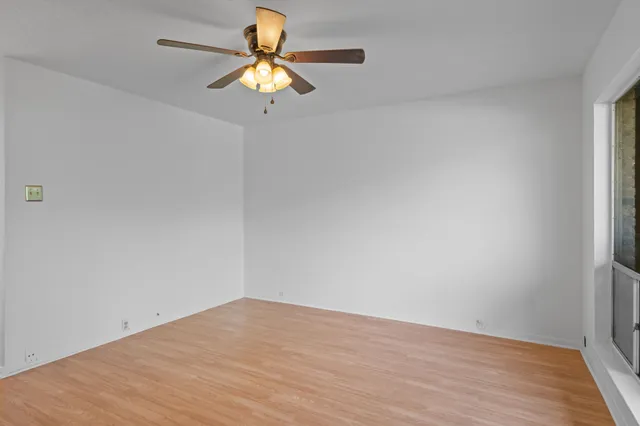 a view of a room with wooden floor and a window