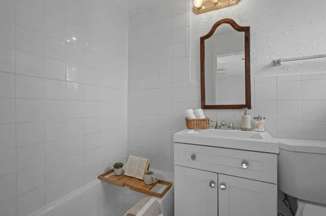 a bathroom with a sink toilet and mirror