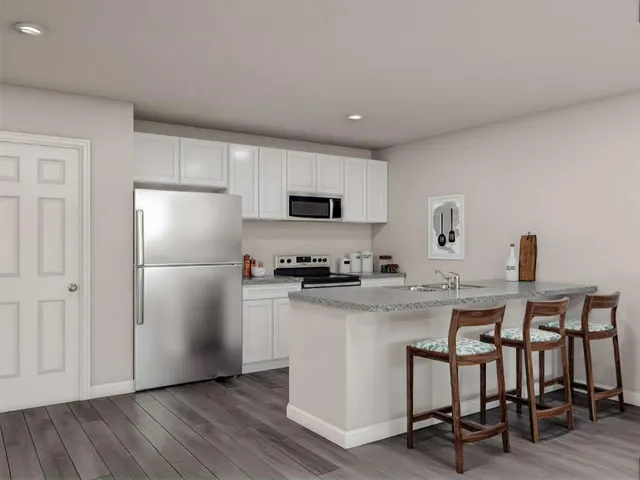 a kitchen with a sink a refrigerator and chairs