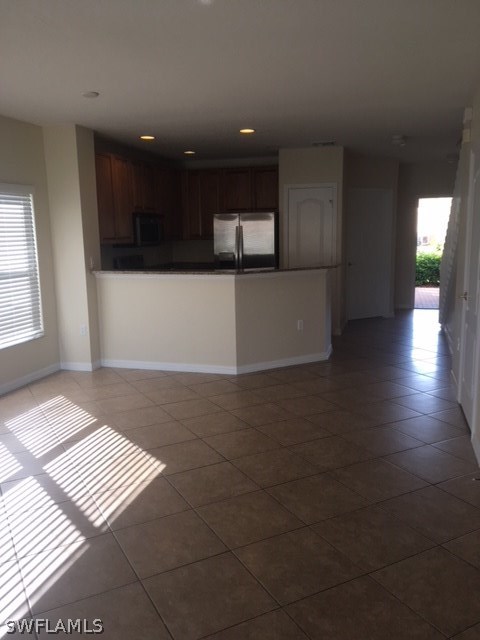 11711 Eros Road Lehigh Acres, FL 33971 - Photo 4 of 13 a view of kitchen with stainless steel appliances a refrigerator and a microwave