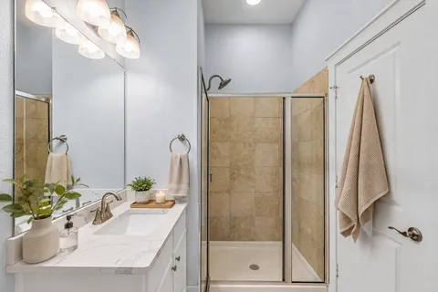 a bathroom with a shower sink and mirror