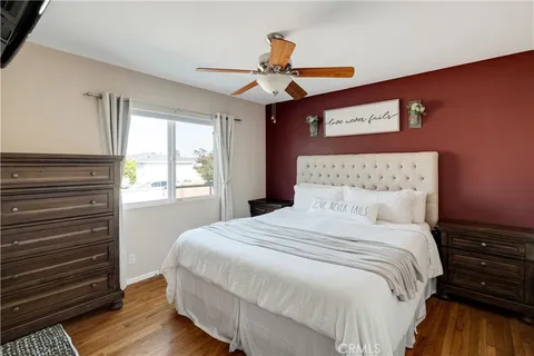 a bedroom with a large bed chandelier and a window