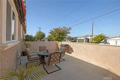 a roof deck with table and chairs and potted plants