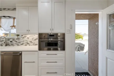 a kitchen with granite countertop white cabinets and stainless steel appliances