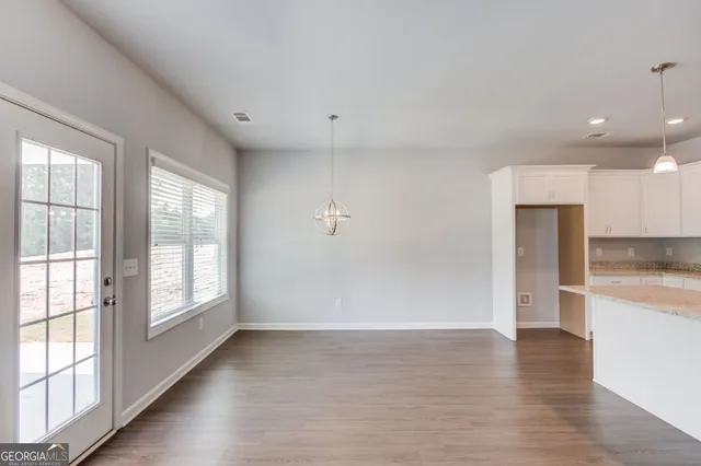 wooden floor in an empty room with a kitchen