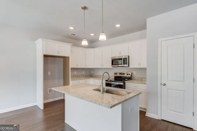 a kitchen with stainless steel appliances granite countertop a sink a stove and a refrigerator