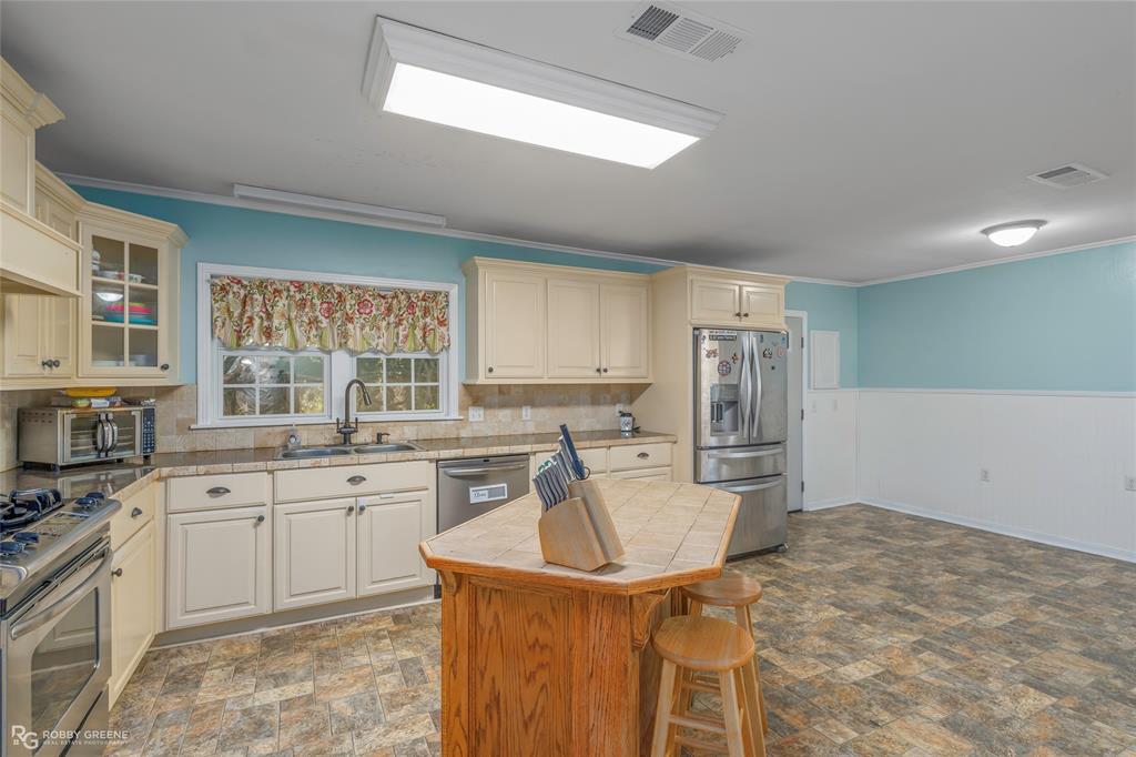 803 Drew Lane Minden, LA 71055 - Photo 9 of 33 a kitchen with granite countertop a sink stove and refrigerator