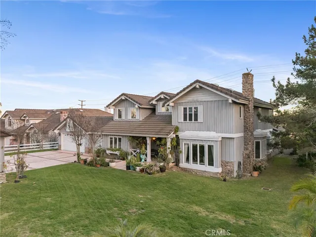 a view of a house with a big yard plants and large trees