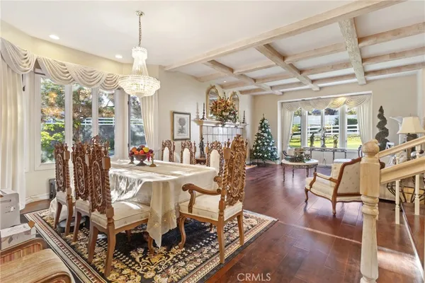 a view of a dining room and livingroom with furniture wooden floor a chandelier