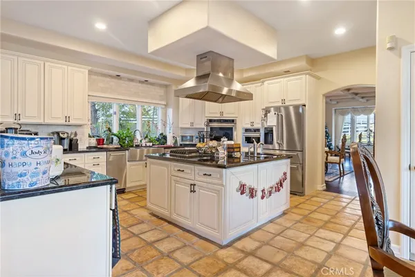 a kitchen with stainless steel appliances granite countertop a sink a stove and a refrigerator