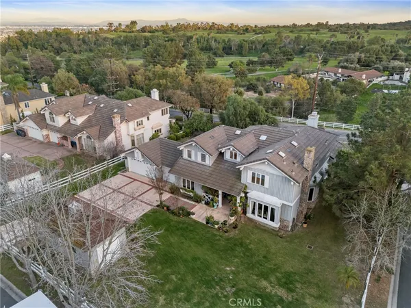 an aerial view of residential houses with outdoor space and trees