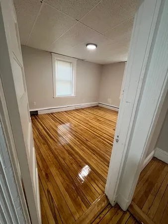 a view of an empty room with wooden floor