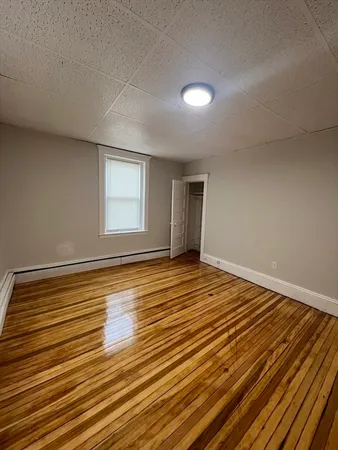a view of a room with wooden floor and window