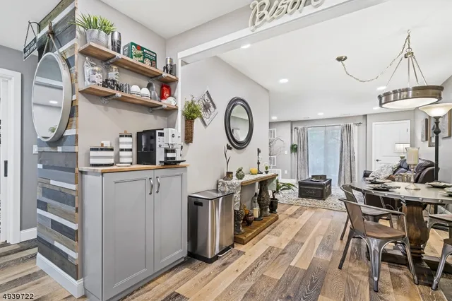 a kitchen with stainless steel appliances granite countertop a refrigerator a stove and white cabinets with wooden floor