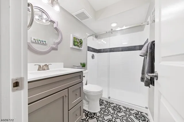 a bathroom with a sink a toilet and a mirror