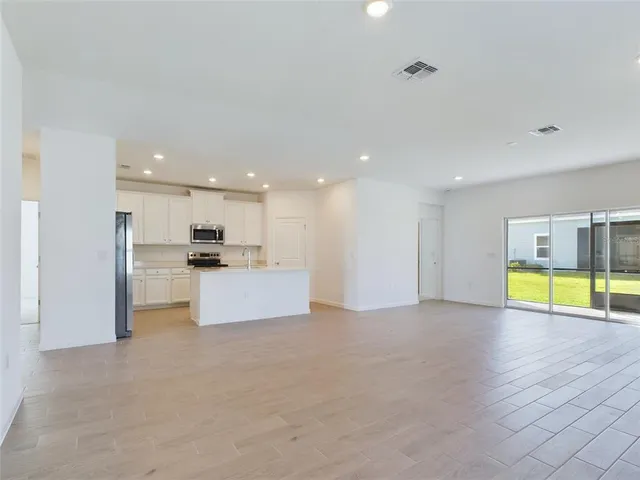 a view of kitchen with kitchen island refrigerator stove microwave and cabinets