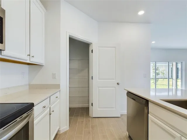 a kitchen with granite countertop white cabinets and white appliances