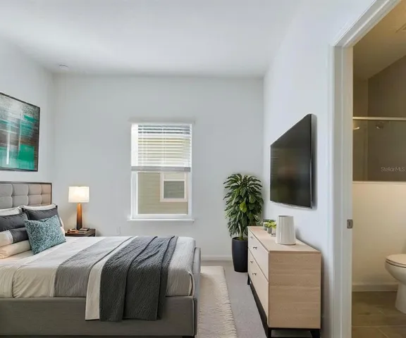 a bedroom with a bed and a flat screen tv