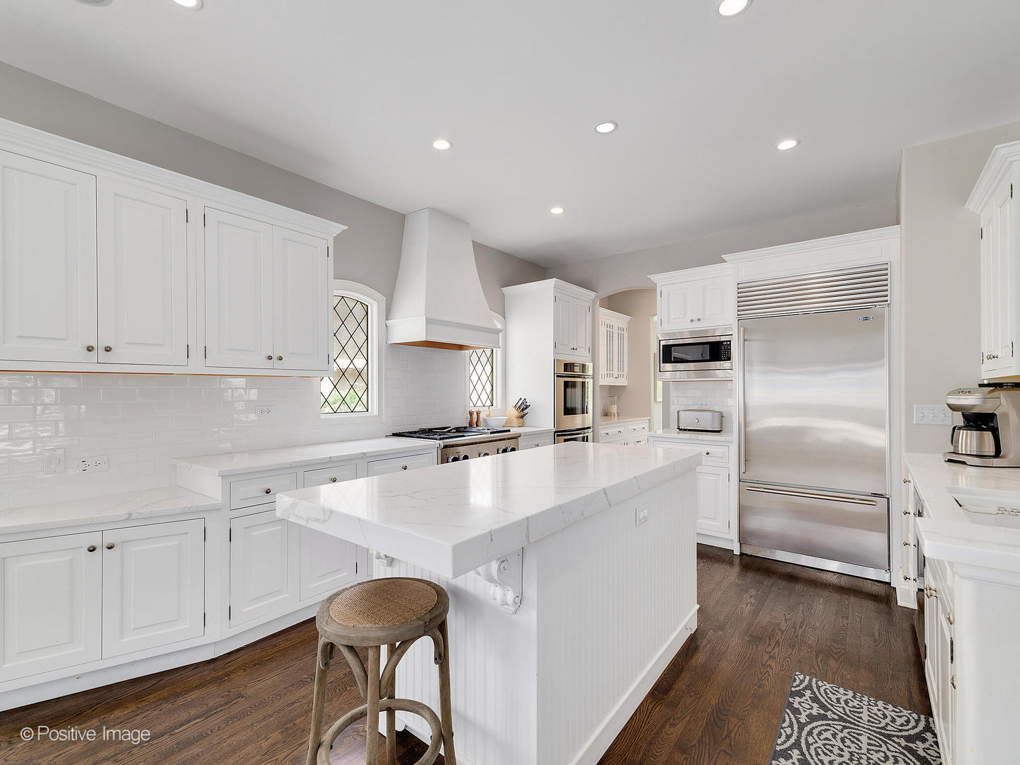 308 North County Line Road Hinsdale, IL 60521 - Photo 17 of 40 a large kitchen with white cabinets stainless steel appliances and wooden floor