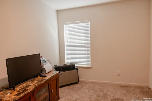 a view of a workspace with furniture and a window