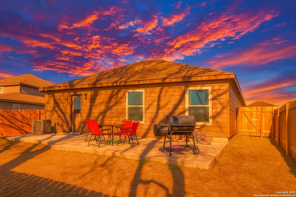 a backyard of a house with table and chairs