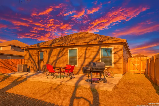 a backyard of a house with table and chairs