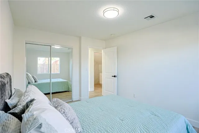 a bedroom with a bed and a wooden floor