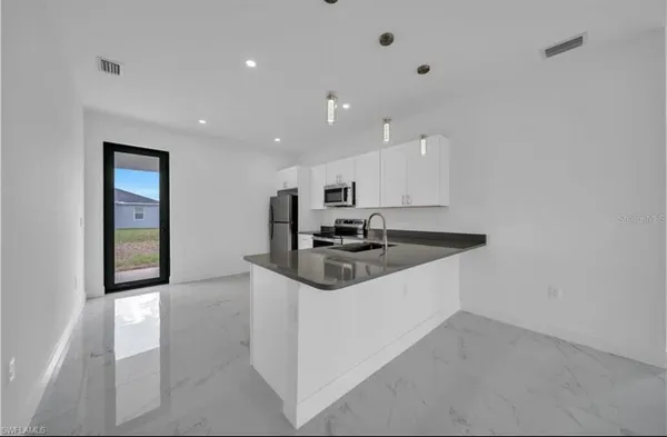 a kitchen with a sink a stove and cabinets