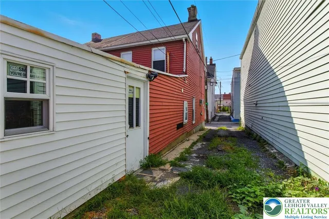 a view of a backyard with a trees and wooden fence