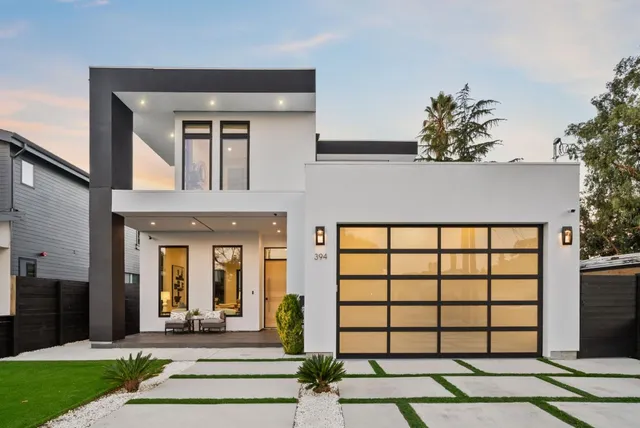 a front view of a house with a garden and plants