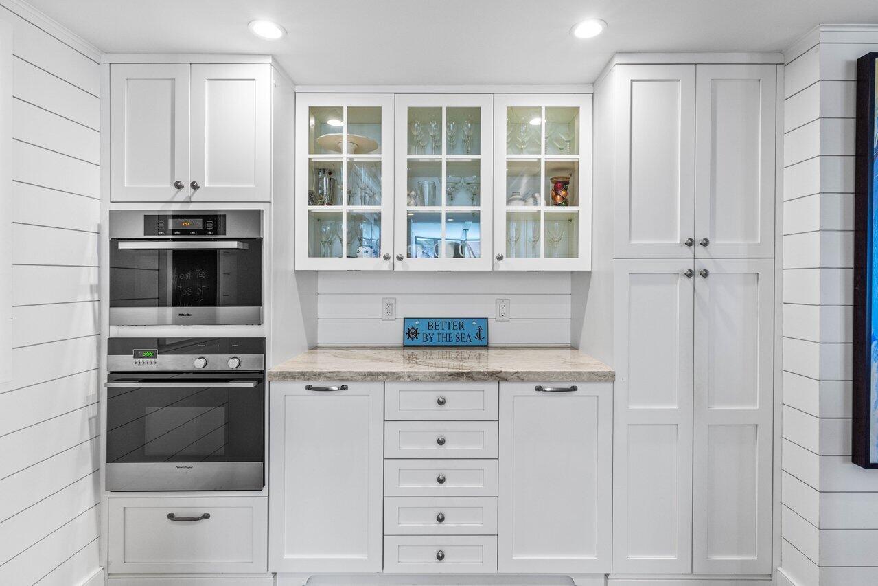 2917 South Ocean Boulevard, Unit 104 Highland Beach, FL 33487 - Photo 12 of 57 a kitchen with stainless steel appliances granite countertop white cabinets and a granite counter tops
