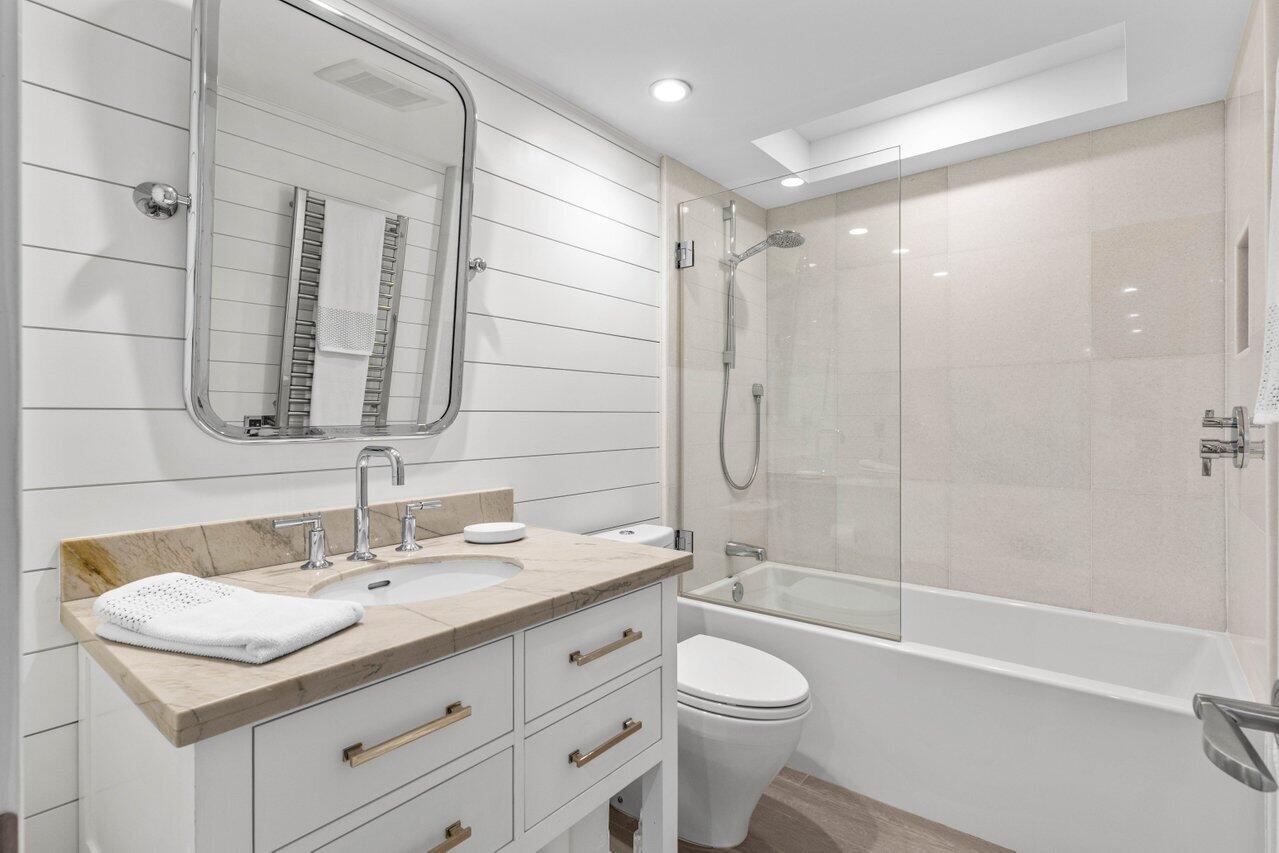 2917 South Ocean Boulevard, Unit 104 Highland Beach, FL 33487 - Photo 22 of 57 a bathroom with a granite countertop sink a toilet and shower