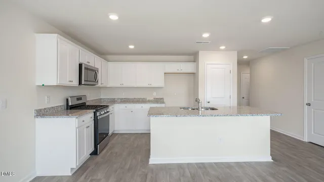 a view of a kitchen with a sink wooden cabinets and stainless steel appliances