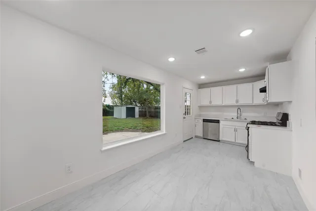 a kitchen with stainless steel appliances granite countertop a stove a sink and a microwave