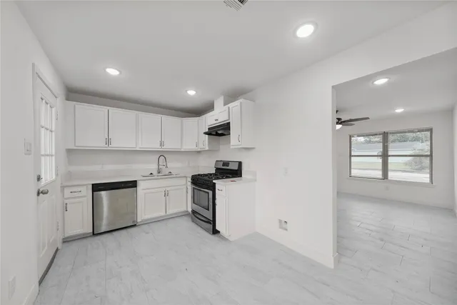 a kitchen with a stove top oven sink and cabinets