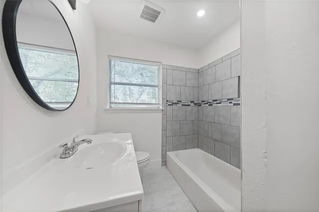 a bathroom with a tub a sink and a mirror