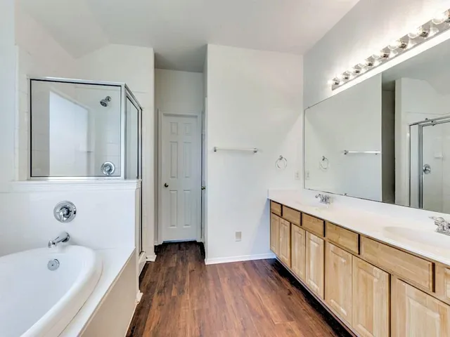 a bathroom with a double vanity sink and mirror with shower