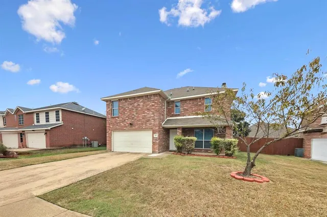 a view of a house with a yard and a garage