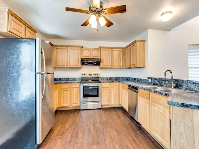 a kitchen with stainless steel appliances granite countertop a sink and cabinets
