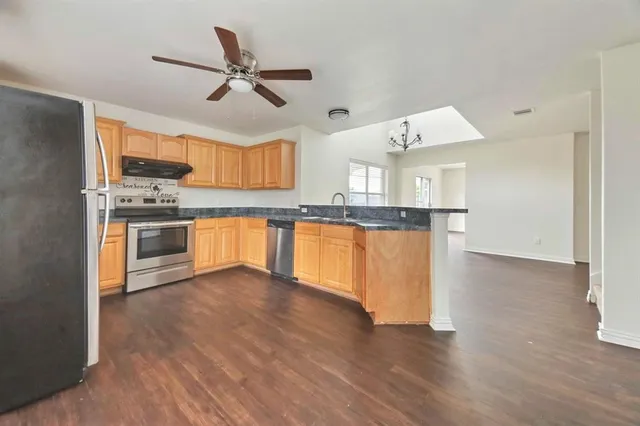 a view of a kitchen with a sink cabinets and wooden floor