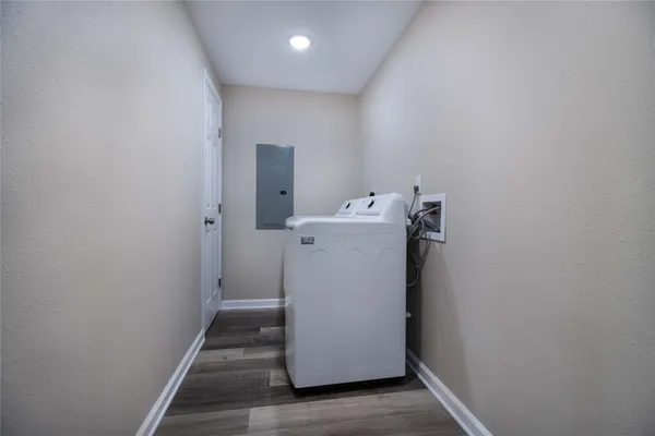 a utility room with wooden floor washer and dryer